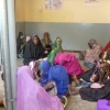 In attesa delle visite mediche coprendosi il volto
